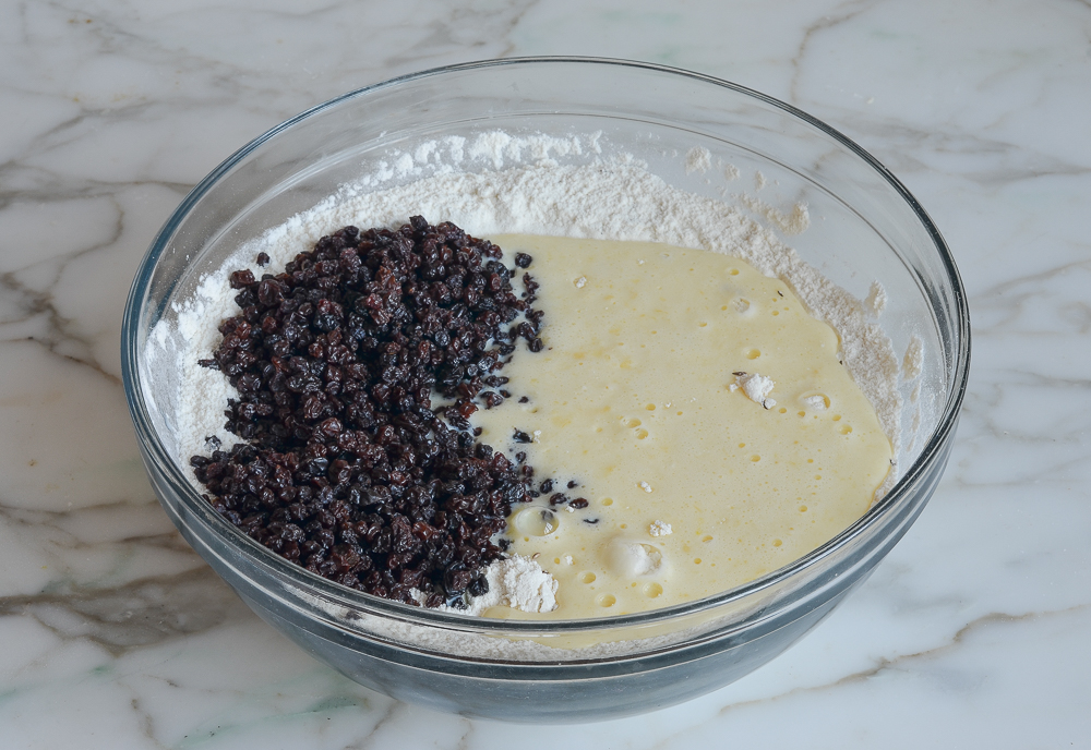 Unmixed bowl of currants, liquid ingredients, and dry ingredients.