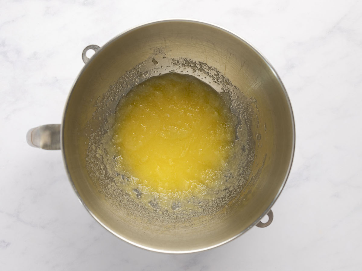 eggs, banana, and vanilla added to melted butter and sugar in metal mixing bowl