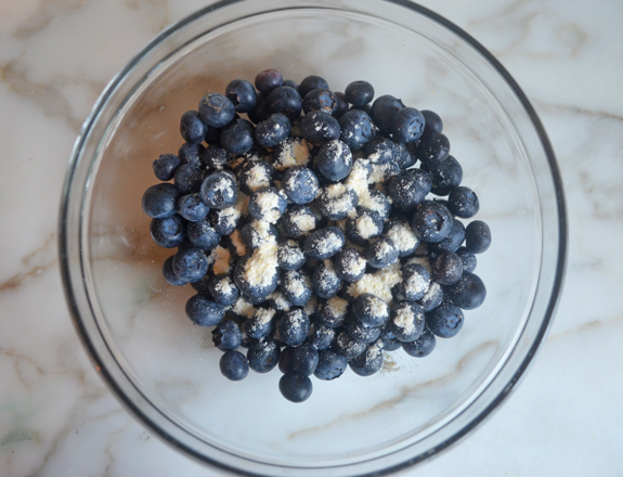 Bowl of blueberries with some cornmeal mixture.