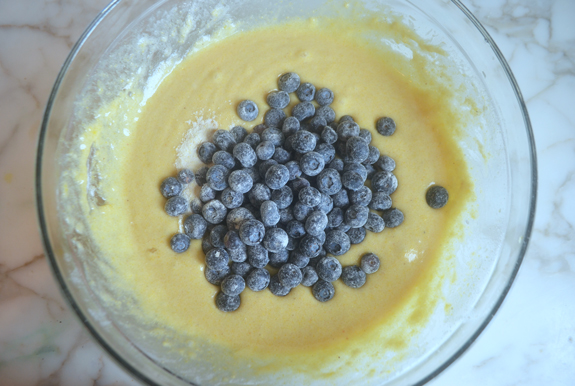 Blueberries in a bowl of muffin batter.