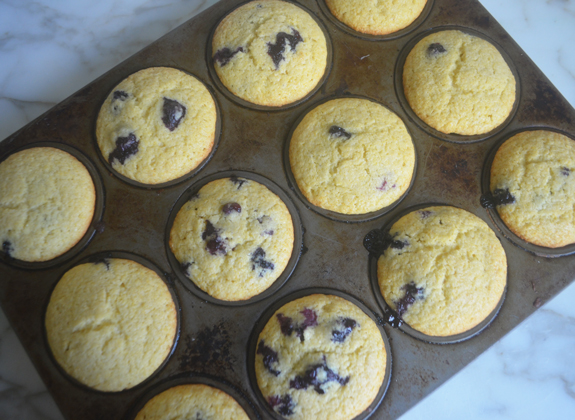 Blueberry cornbread muffins in a muffin pan.