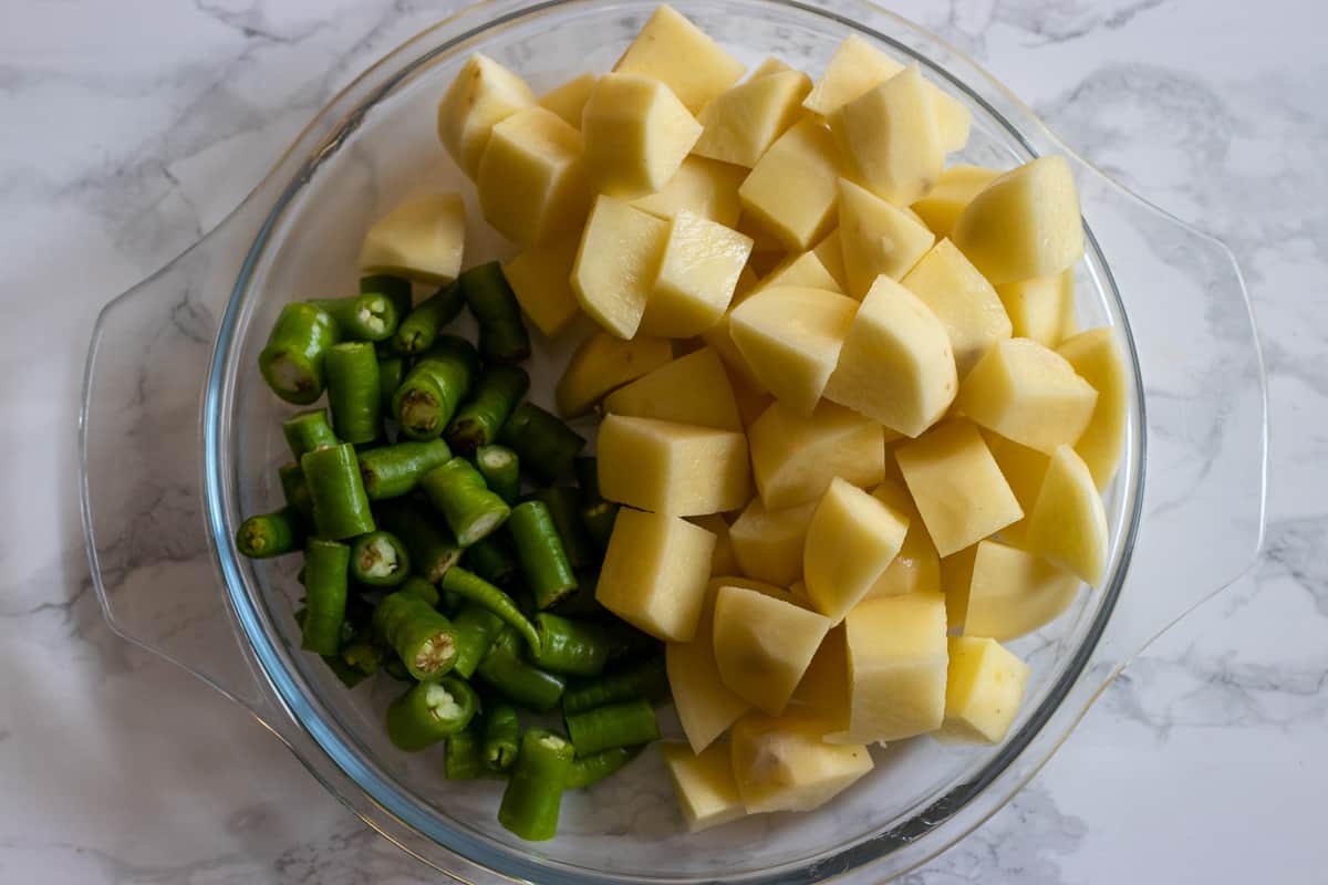 potatoes are cut in cubes and sliced peppers are in a bowl