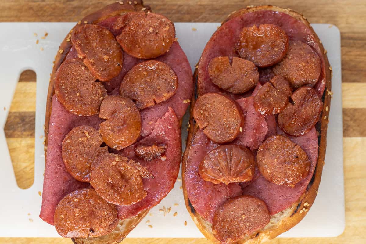 cheese, salami and sucuk are placed on grilled kumru bread