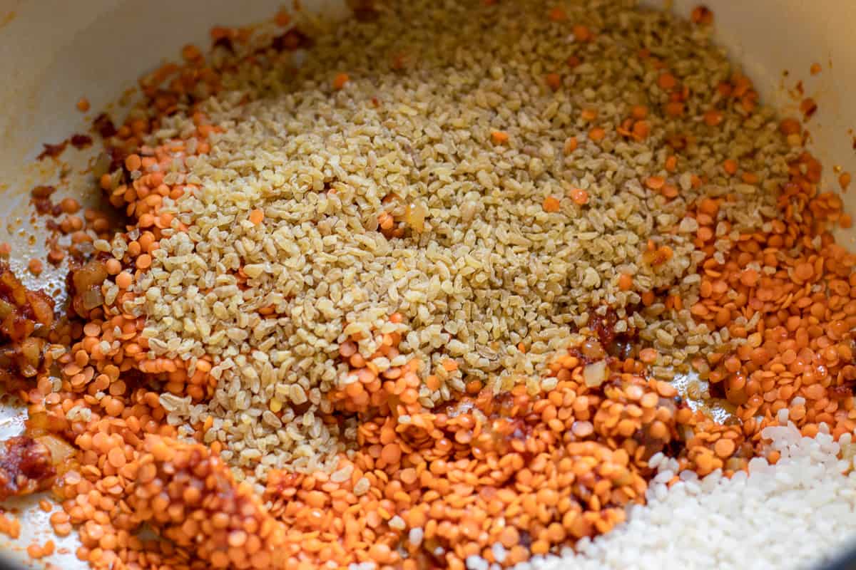 the lentils, bulgur and rice are added to the sautéed onions