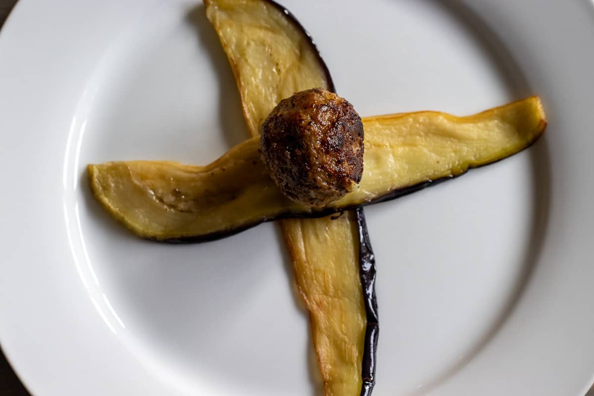 a piece of meatball is placed on aubergine slices