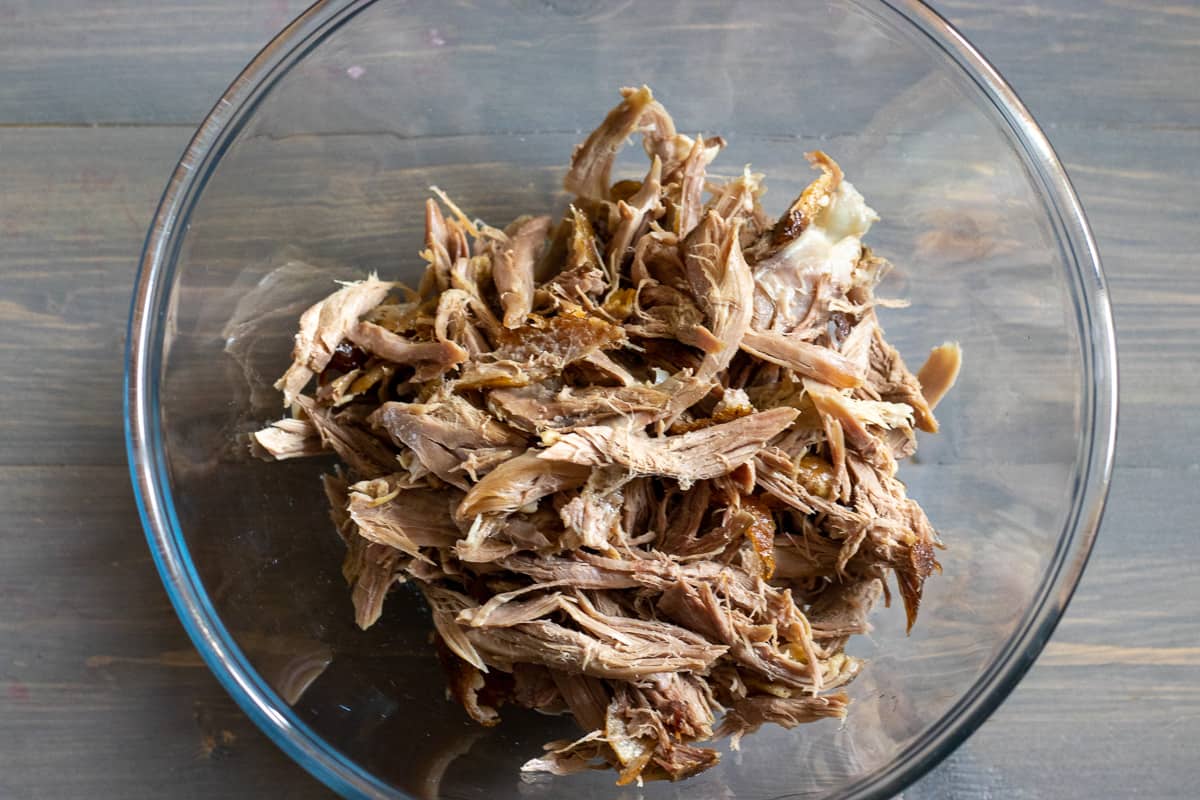 shredded duck meat in a glass bowl