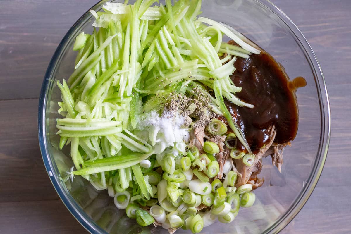 shredded duck, cucumbers, spring onions and hoisin sauce are placed in a bowl