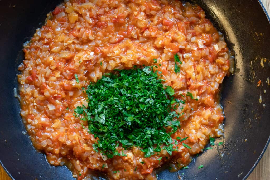 Chopped parsley is added to the onion&tomato mixture