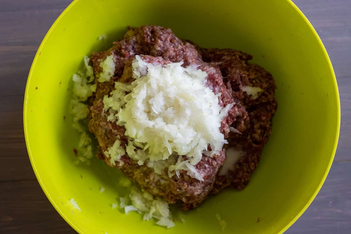 grated onions and lemon mixture are added to the ground beef