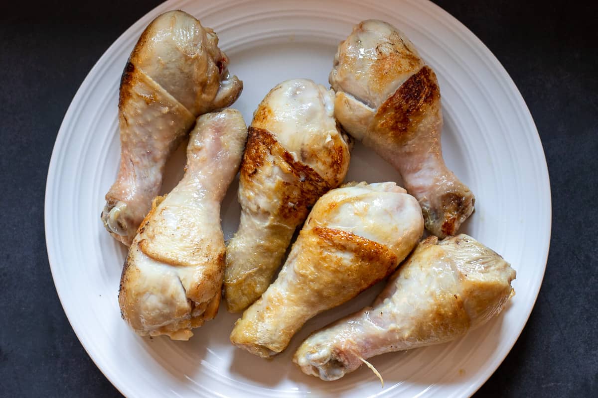 6 pieces of seared chicken legs on a plate