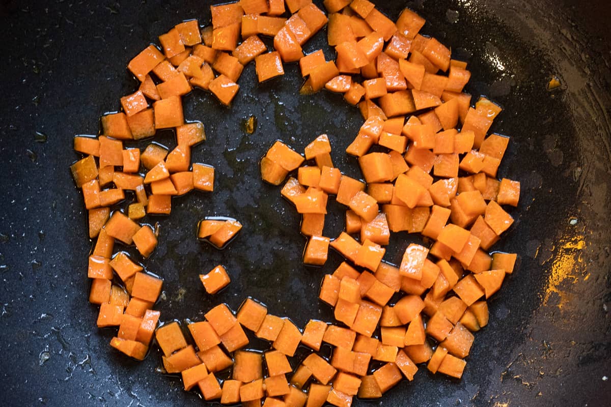 Sautéing the carrots in a wok for spicy egg fried rice