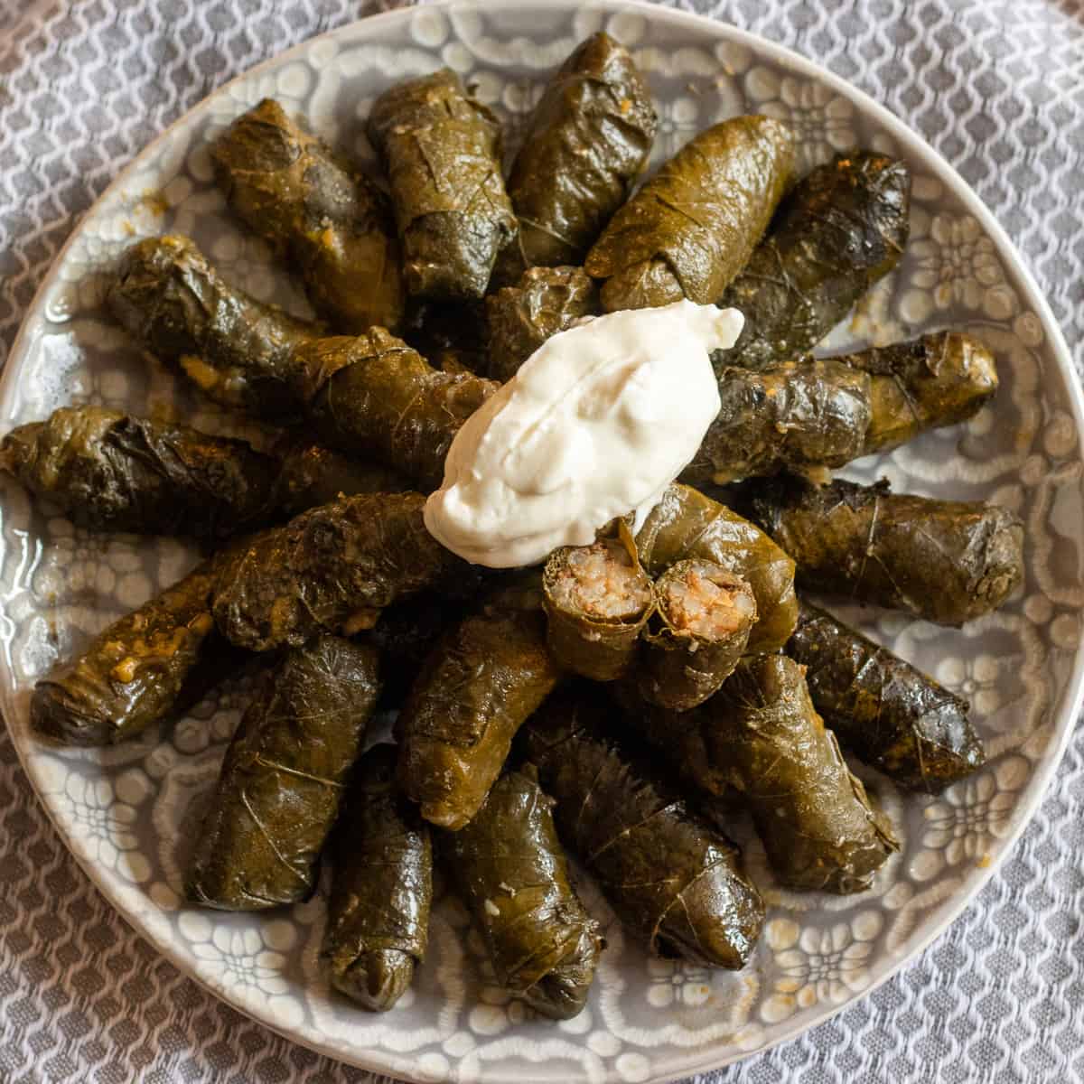 Meat stuffed grape leaves (dolmas)served with a dollop of yoghurt