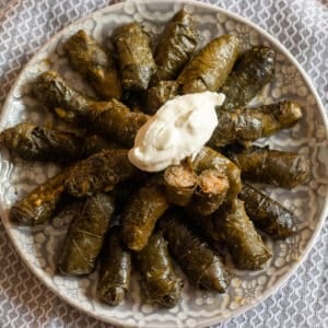 Meat stuffed grape leaves (dolmas)served with a dollop of yoghurt