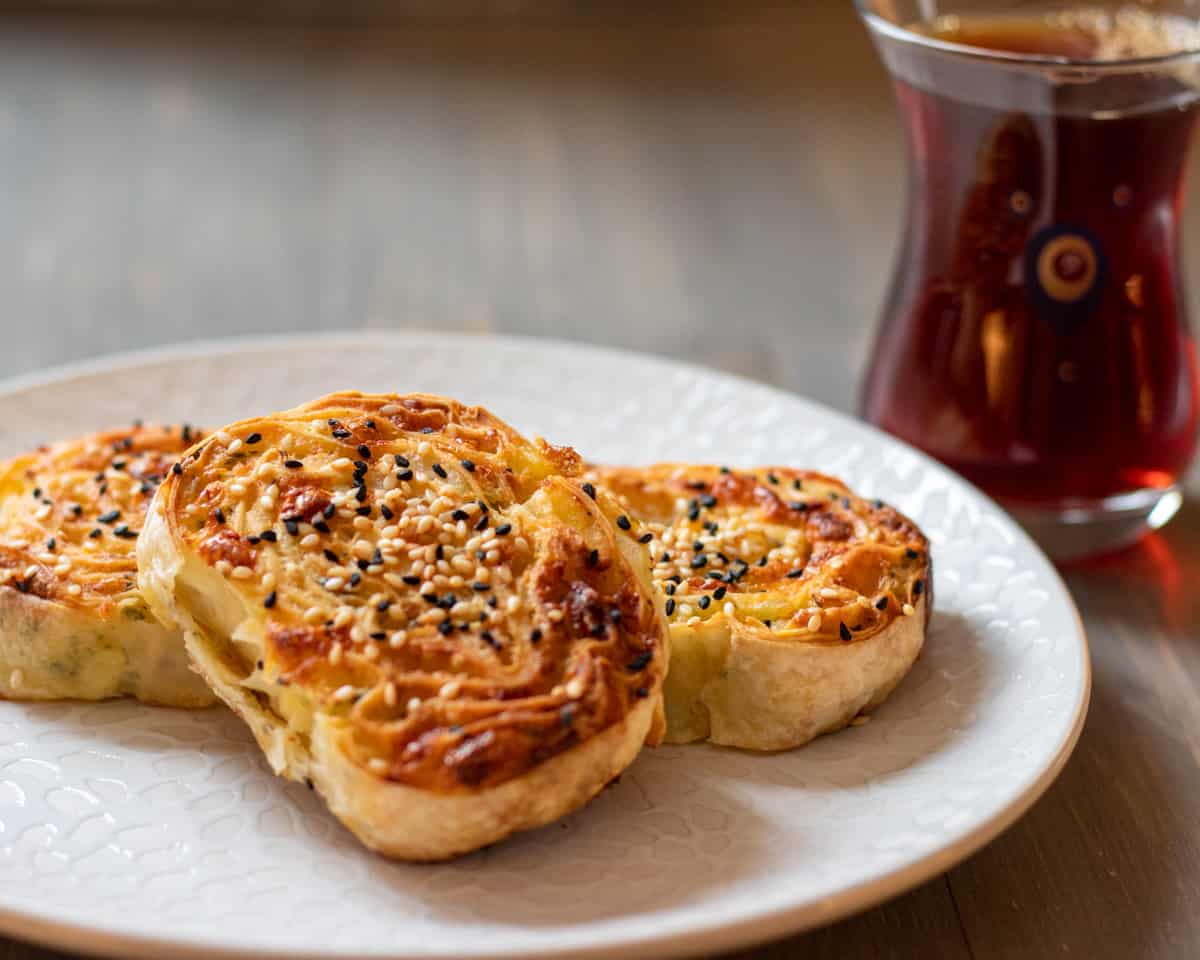 3 slices of potato borek served with a cup of Turkish tea