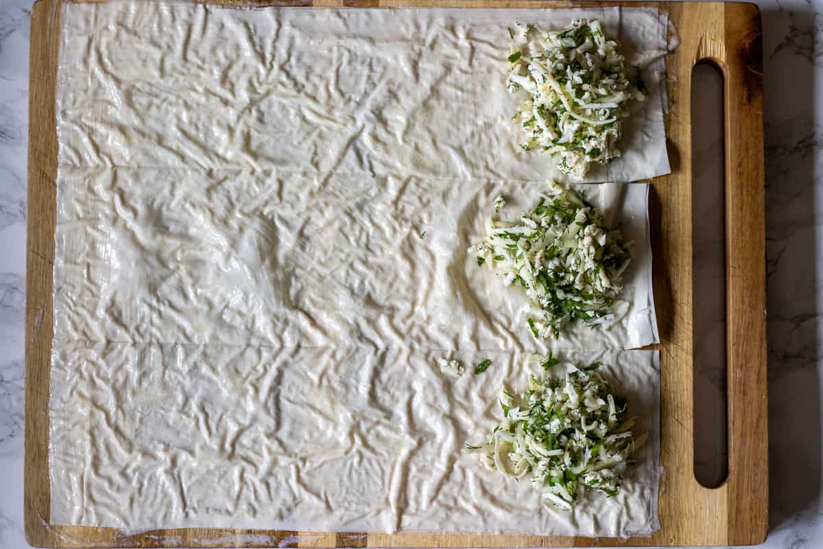 filo sheets are cut into 3 pieces and topped with cheese filling
