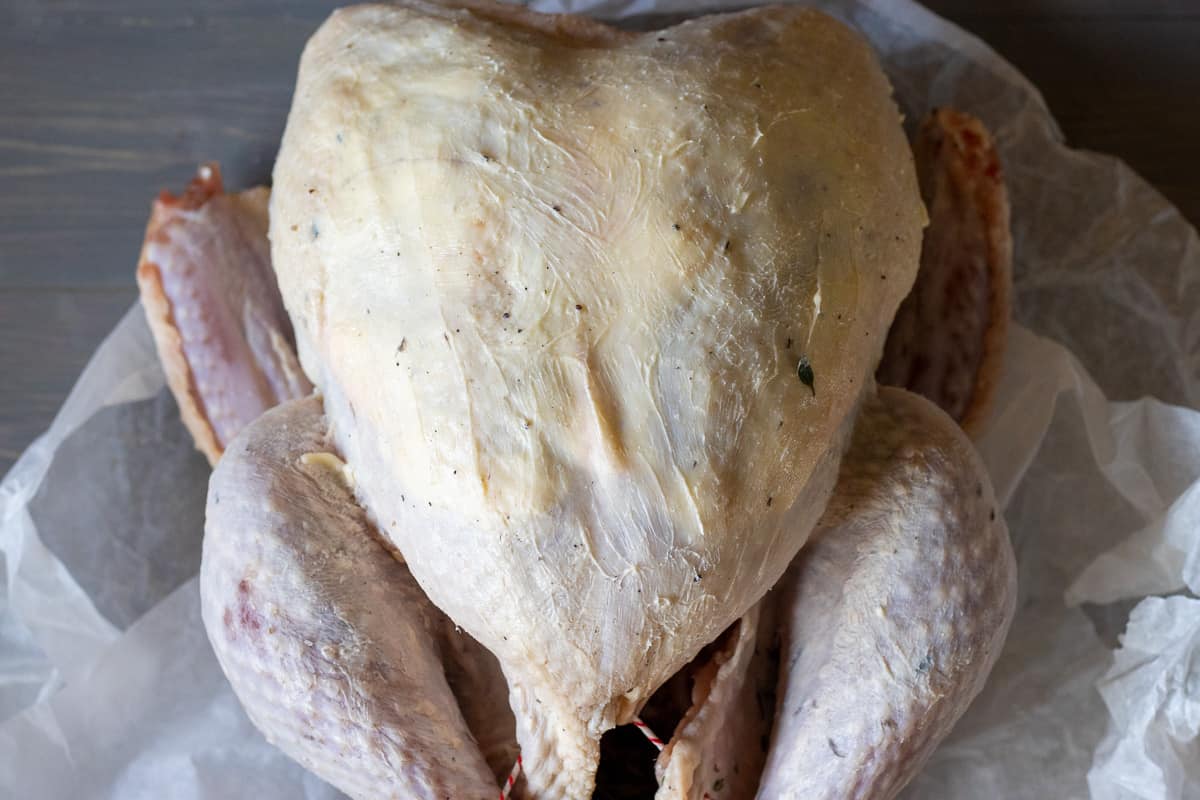 softened butter is spread underneath the skin of turkey breast