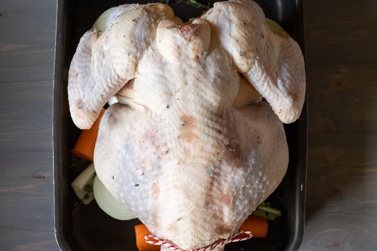 turkey is placed on vegetables breast side down before roasting