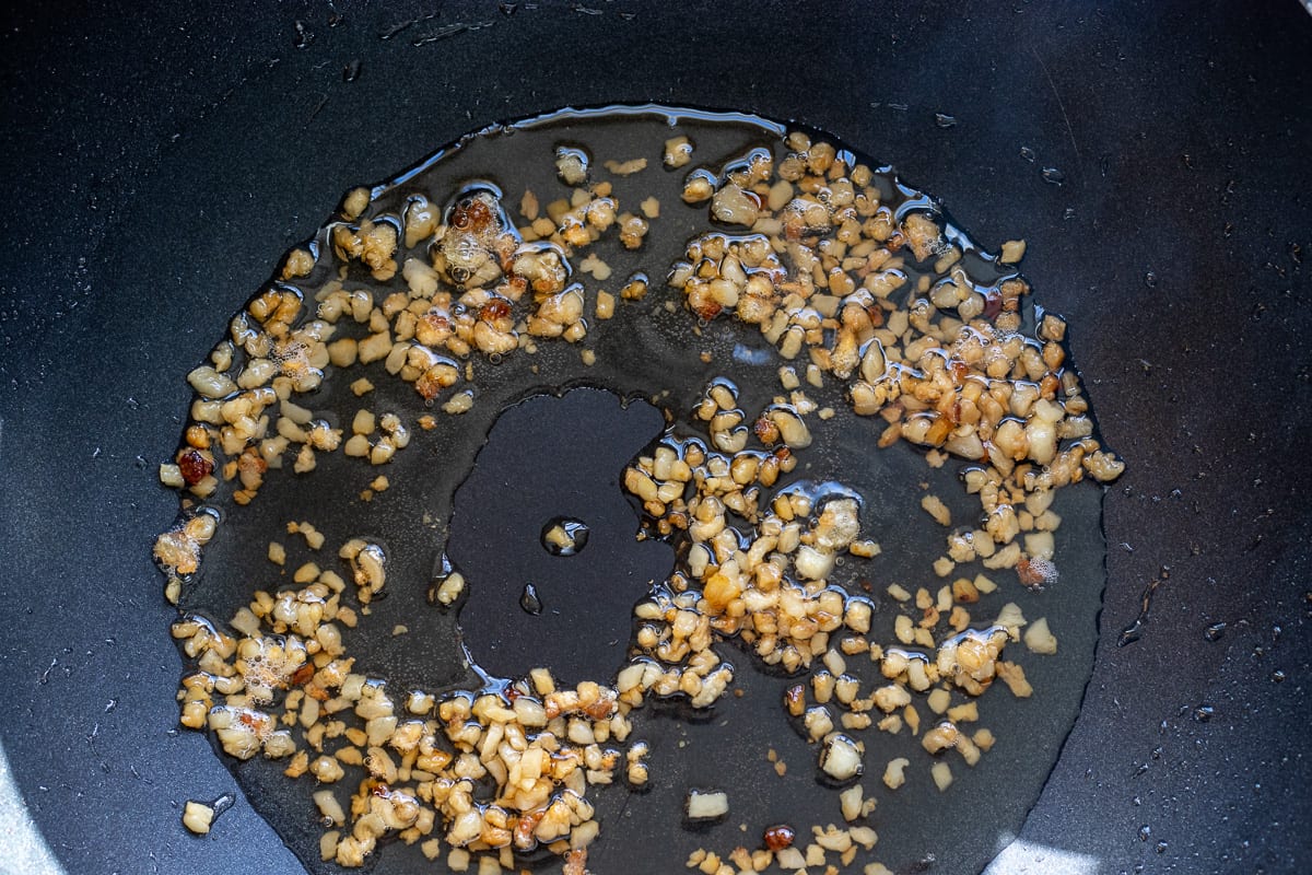 Lamb fat being rendered in a wok
