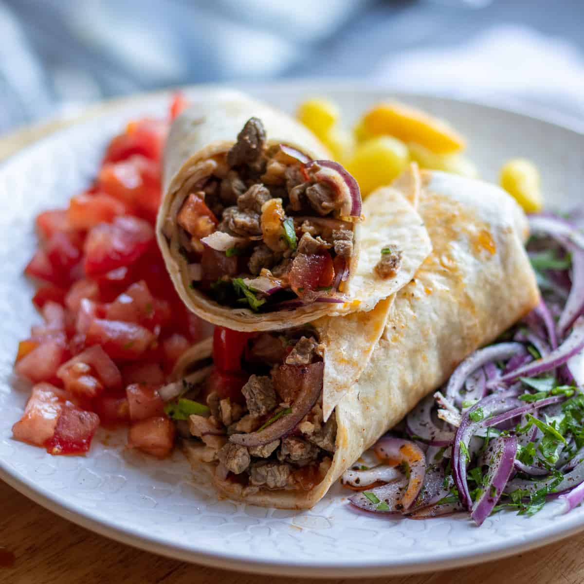 Tantuni is served with chopped tomatoes, onion salad and pickled chillies