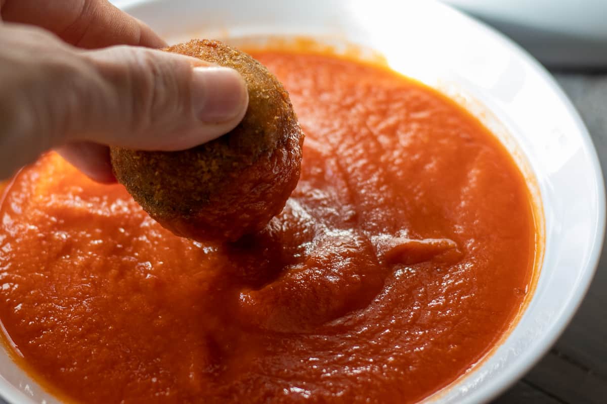 risotto ball dipped in tomato sauce