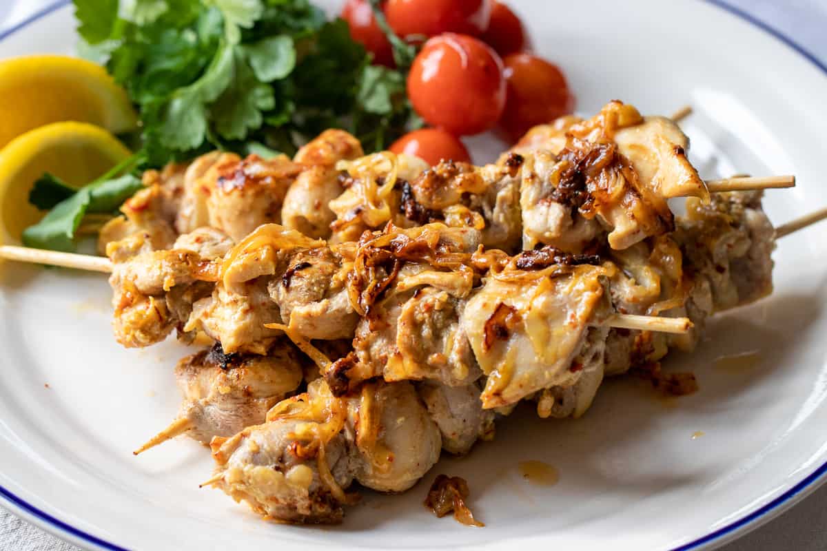 Grilled joojeh kabab is served with tomatoes and parsley