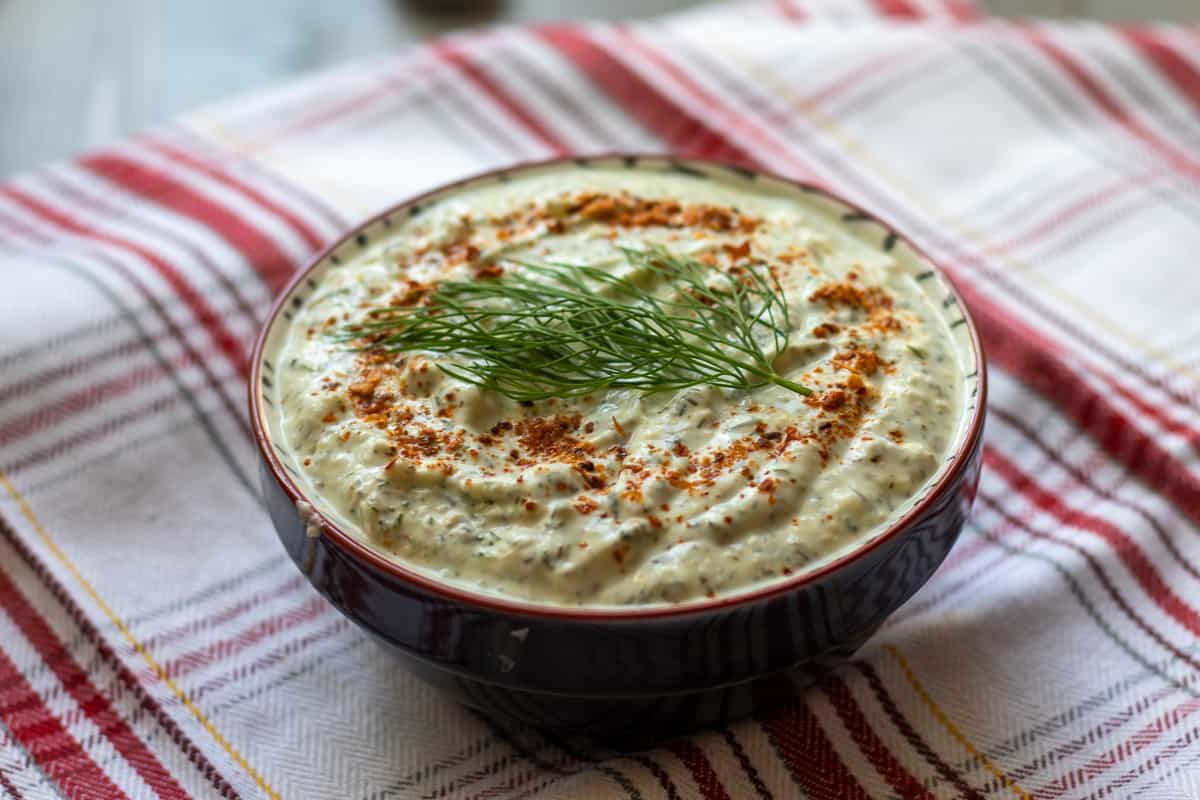 haydari served in a bowl garnished with dill and chili flakes