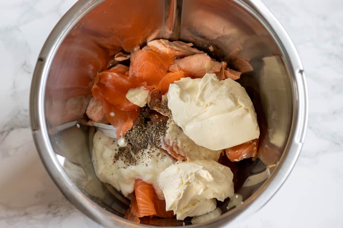 salmon, smoked salmon, cream cheese, horseradish and pepper are placed in a bowl of a food processor 