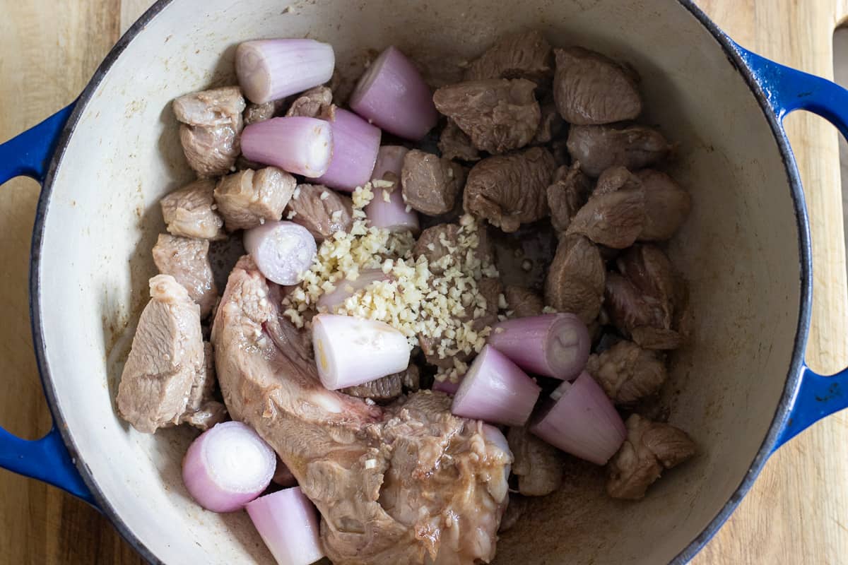 shallots and onions are added to the lamb for sautéing 