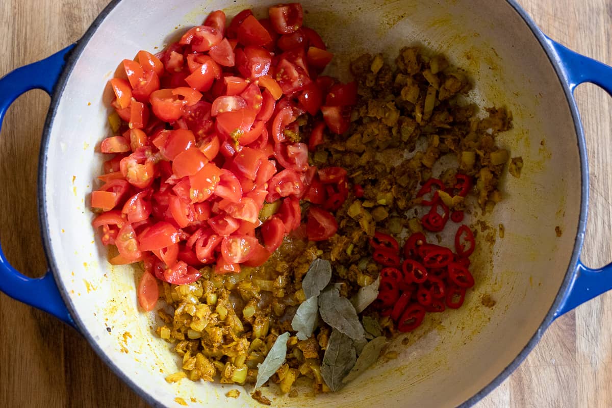 the tomatoes, chilies and curry leaves are added to the pan