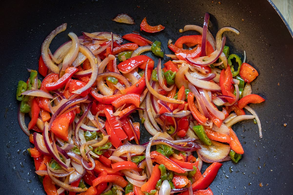 Sautéing the red onions with peppers 