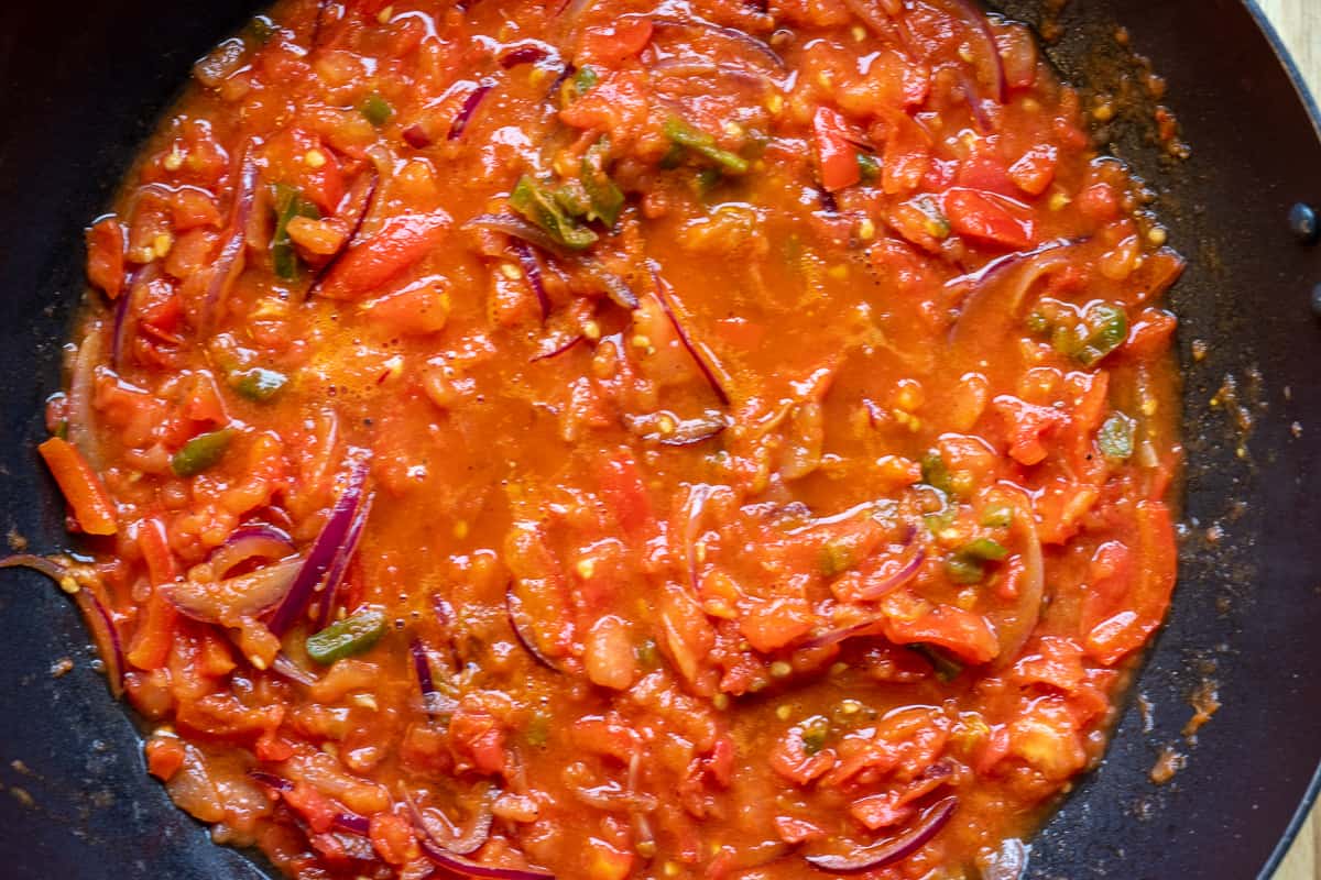 The tomatoes are added to the pan for finishing the sauce