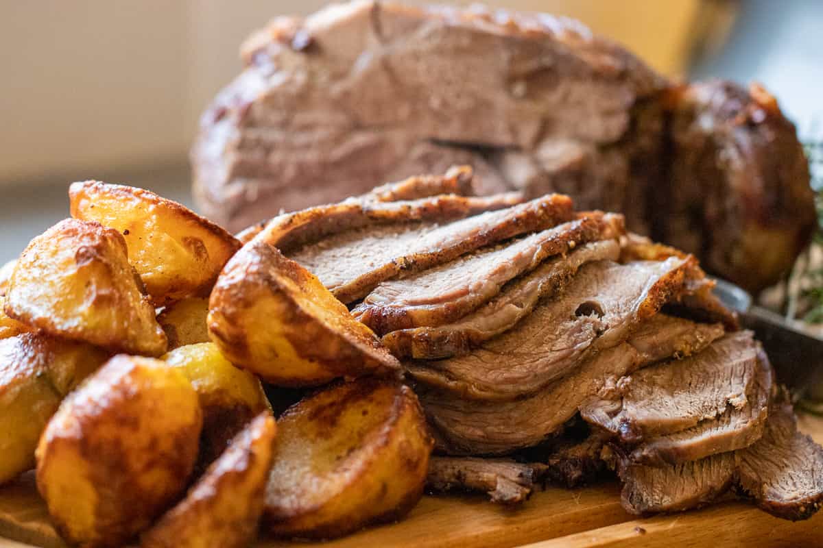 roasted butterflied leg of lamb slices and roasted potatoes