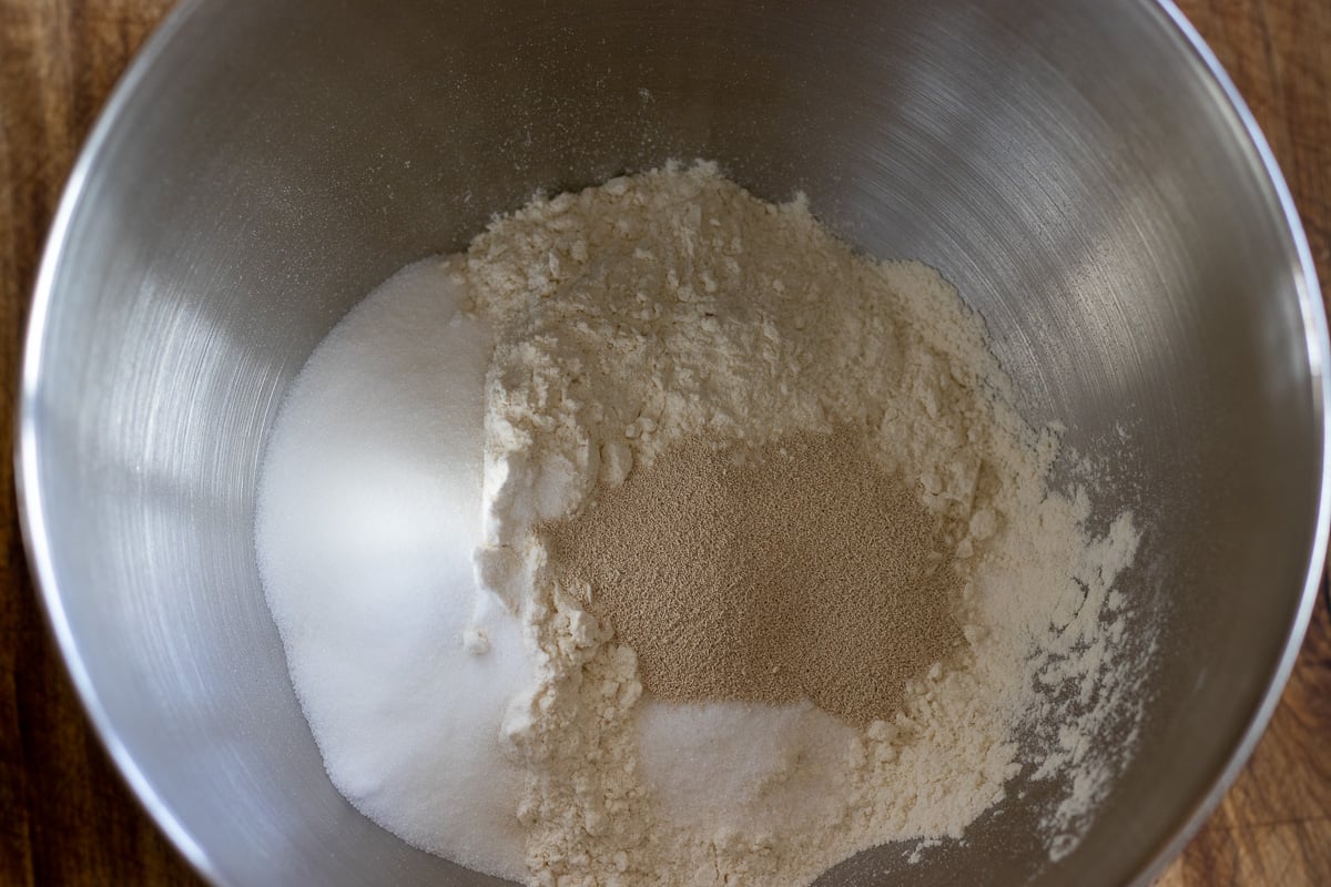 dry ingredients are placed in a bowl of a stand mixer