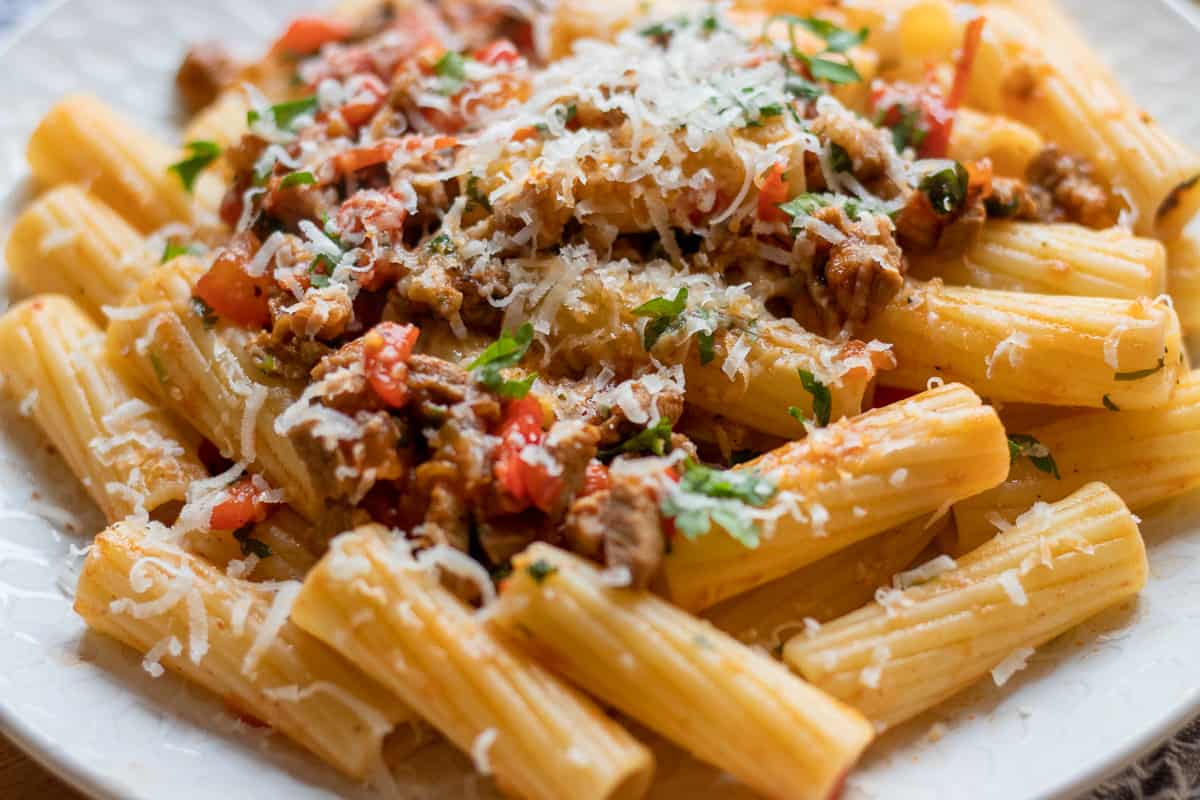 braised lamb ragu is served on pasta and garnished with parsley and parmesan