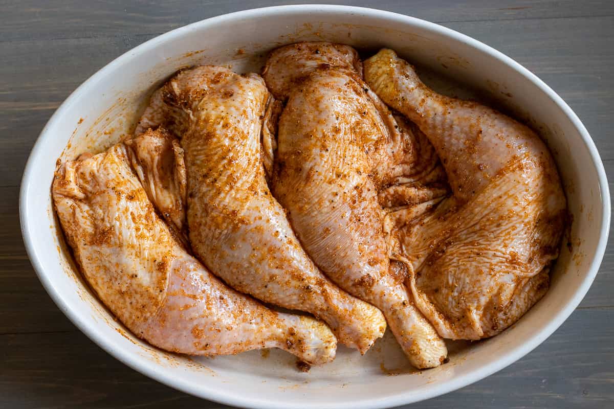 chicken legs are rubbed with spices and olive oil