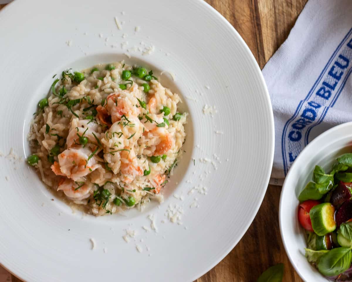 creamy prawn risotto served with a bowl of salad