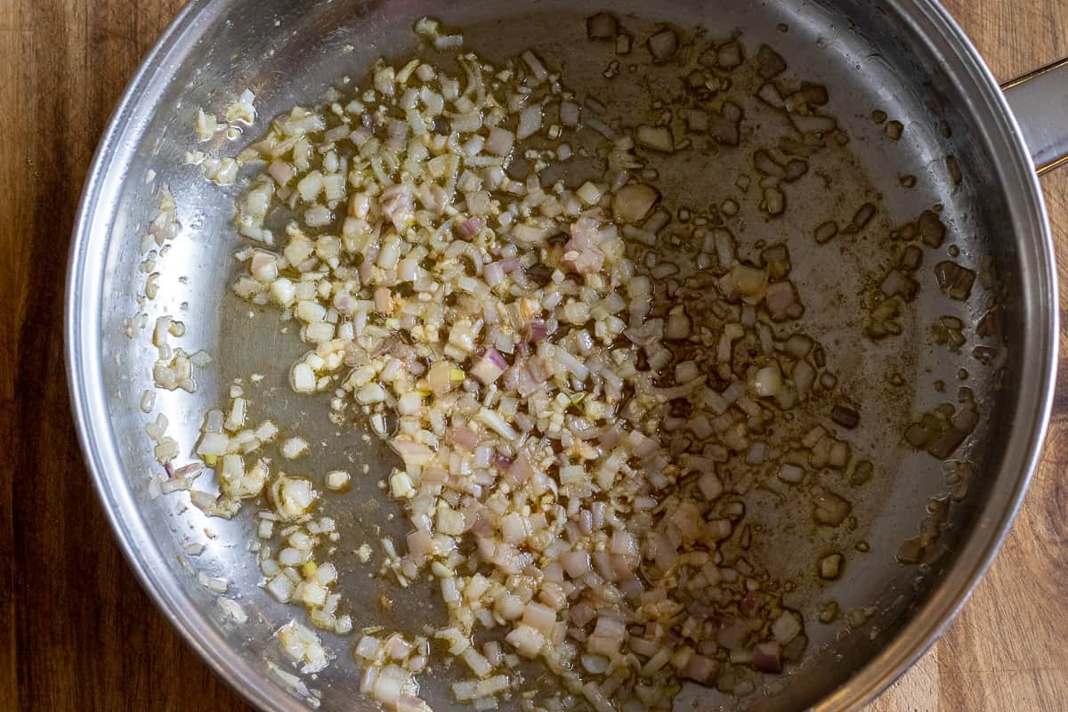 Sautéing shallots and garlic in a pan with olive oil