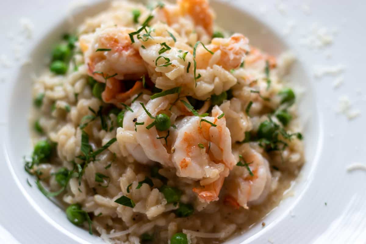 shrimp risotto is served with grated parmesan and chopped parsley