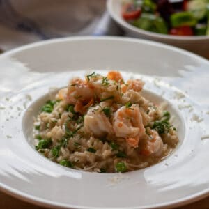 creamy shrimp risotto served in a bowl and garnished with parmesan