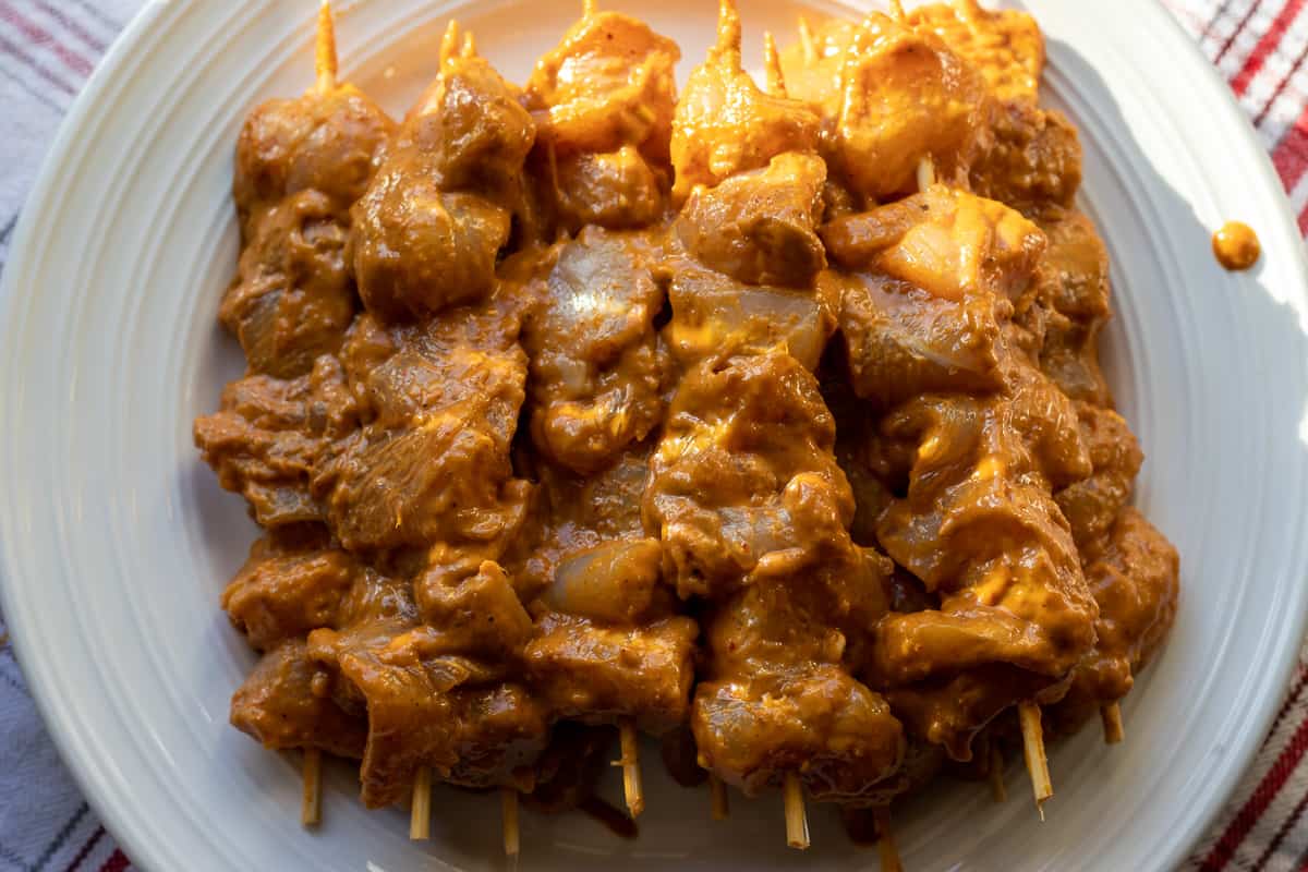 marinated chicken pieces are threaded onto skewers