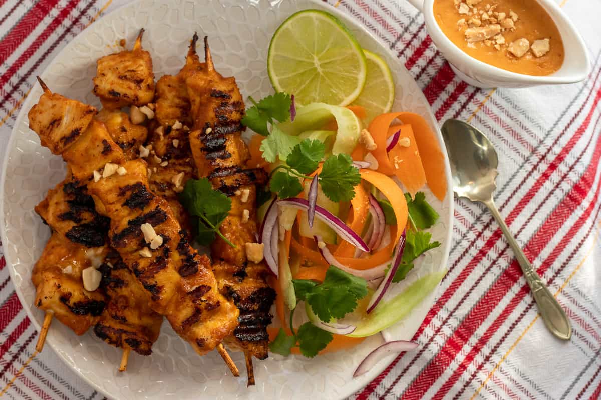 thai chicken satay is served with salad and peanut sauce