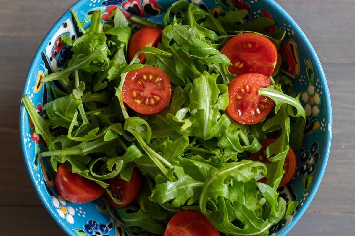 tomatoes are added to rocket leaves
