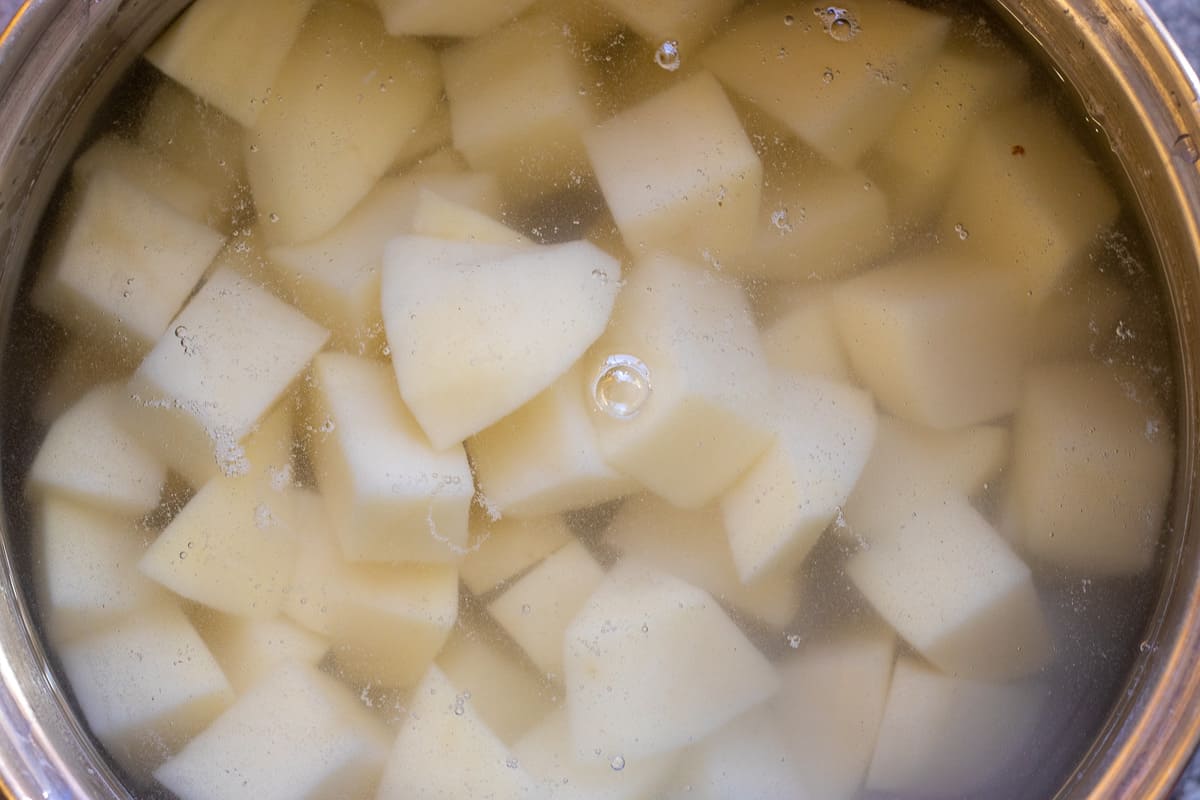 the potatoes are placed in a pan with water and cook until soft