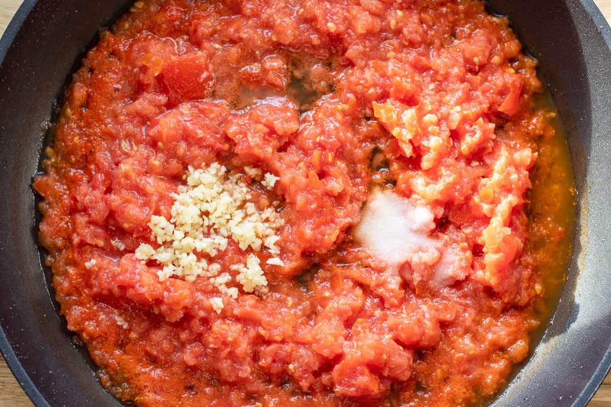 grated tomatoes, garlic and salt in a pan for the sauce