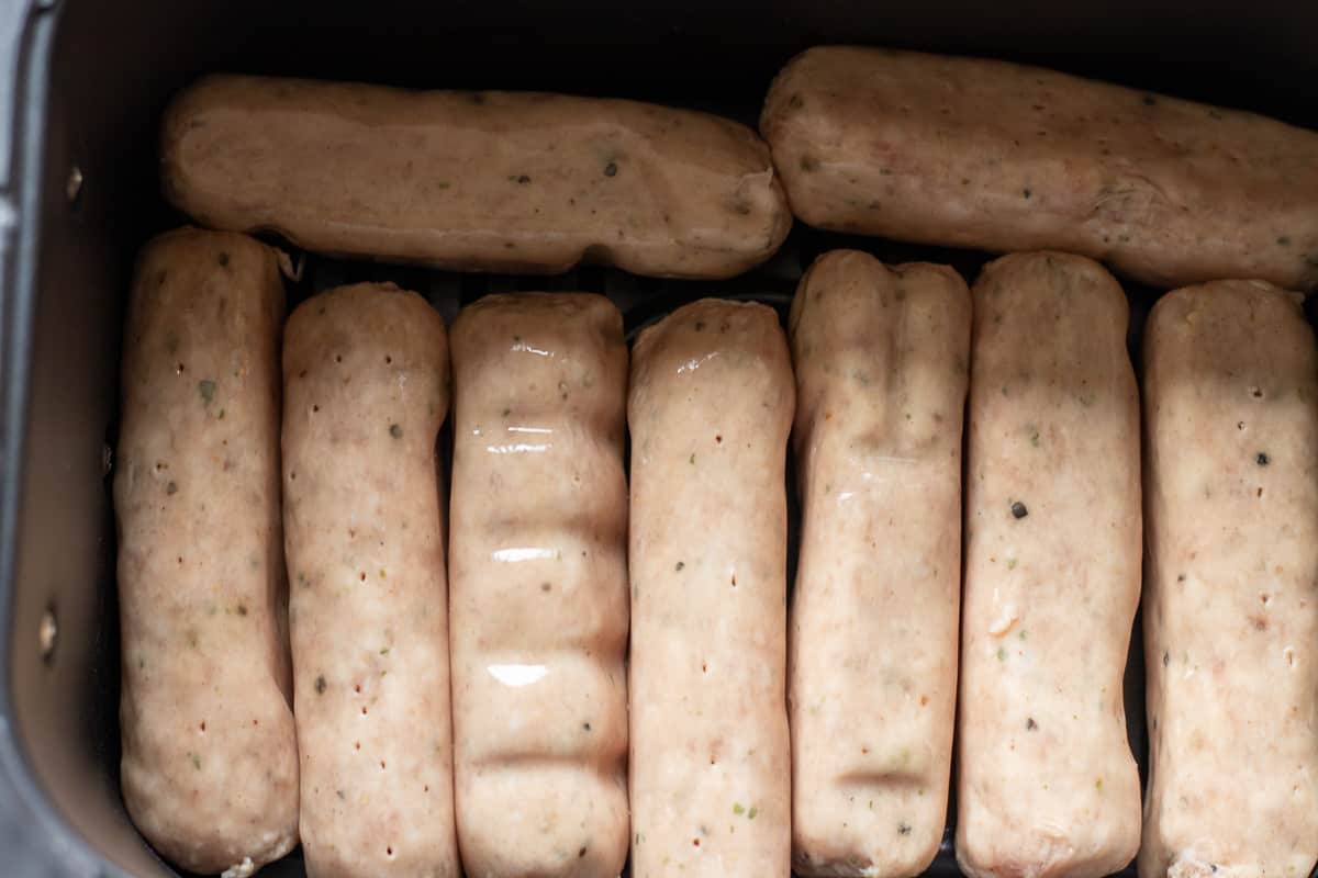 sausages arranged in an air fryer basket