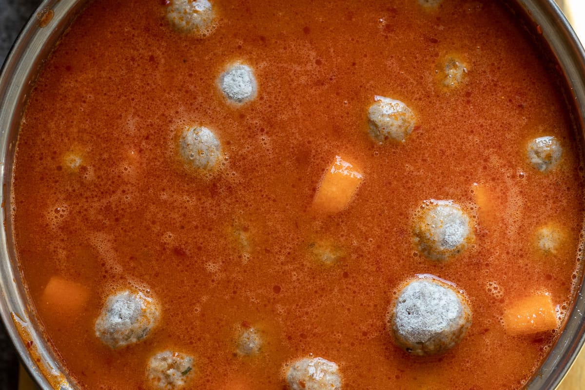 the meatballs and stock are added to the pan
