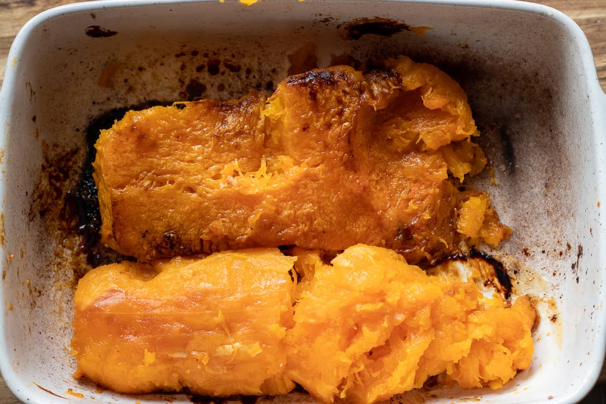 roasted butternut squash is scooped out of its skin
