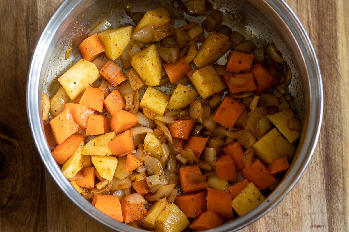 potatoes and carrots are added to the onions