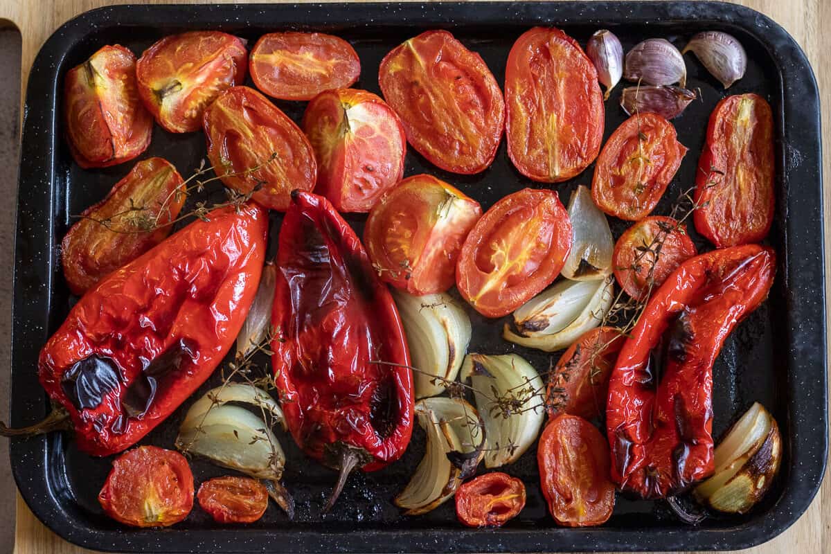 roasted red peppers, tomatoes, onion and garlic on a tray