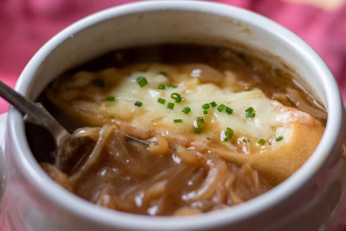 eating French onion soup with a spoon